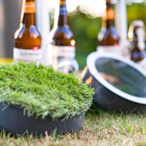 Biersafe grass and glass caps lie in the grass